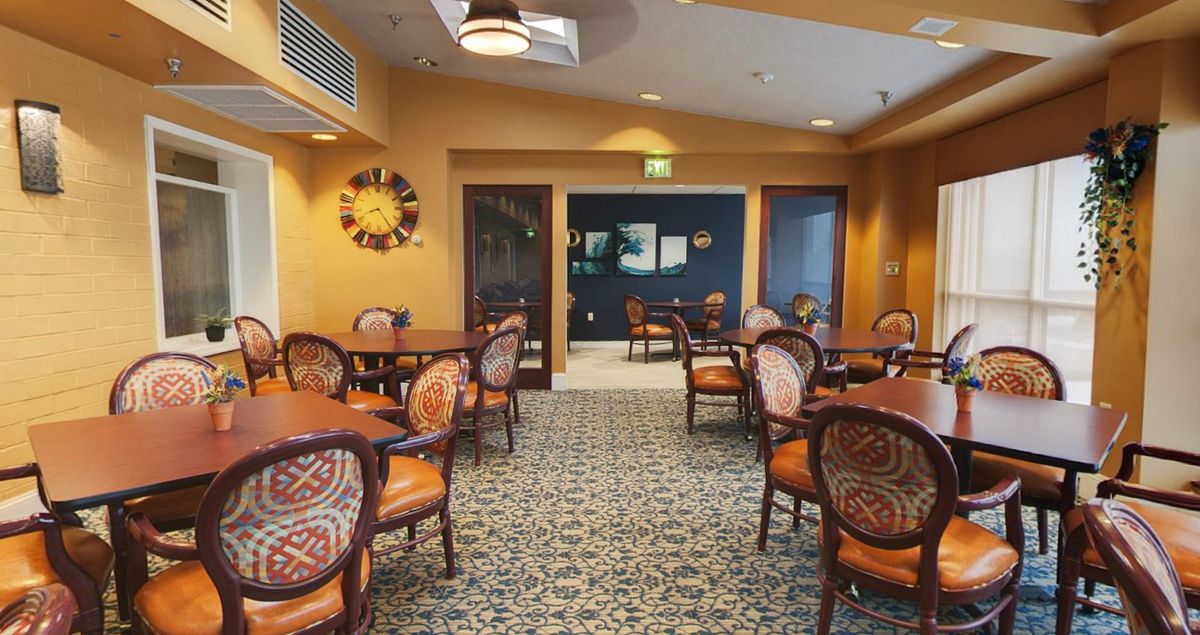 An inviting cafe interior with well-arranged tables and chairs, enhanced by warm lighting and decor.