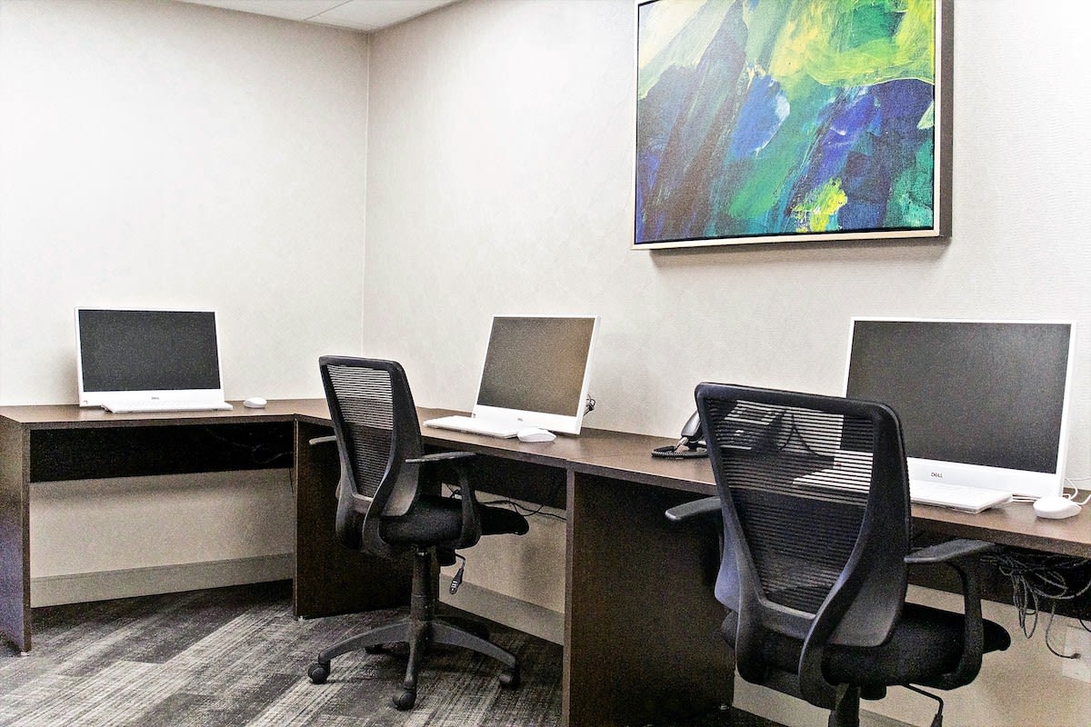 A modern office setup with multiple workstations and abstract wall art.