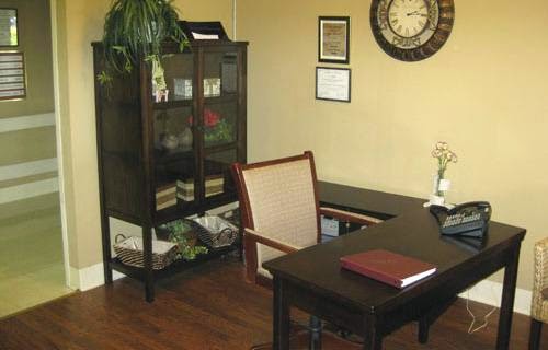 A neatly organized office space featuring a desk, bookshelf, and decorative elements.