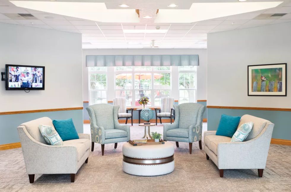 A modern living room with comfortable seating and turquoise accents, bathed in natural light.