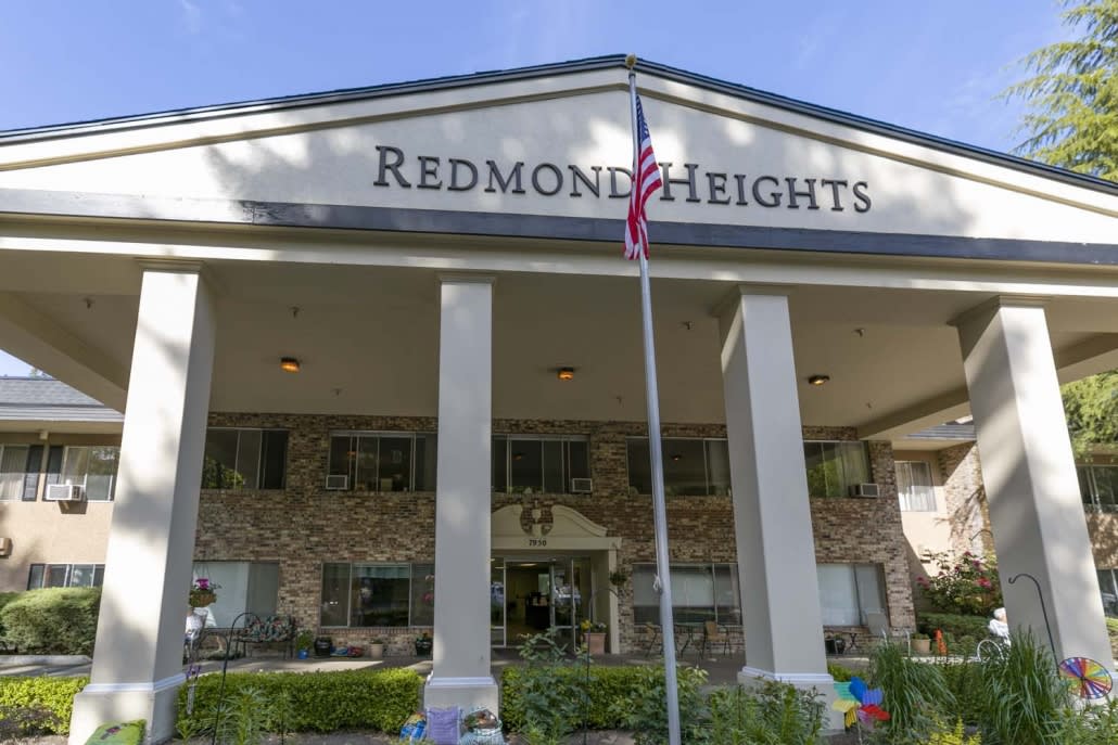 Front view of the Redmond Heights building with prominent columns and a flagpole.