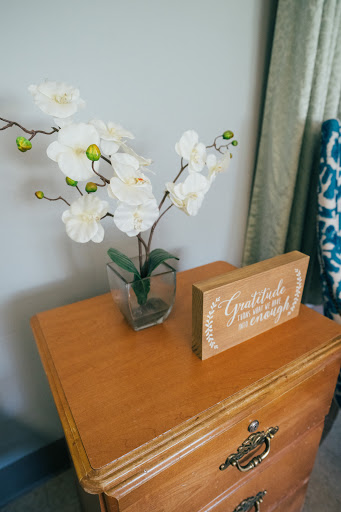 A serene corner featuring an elegant orchid arrangement and a charming wooden sign.