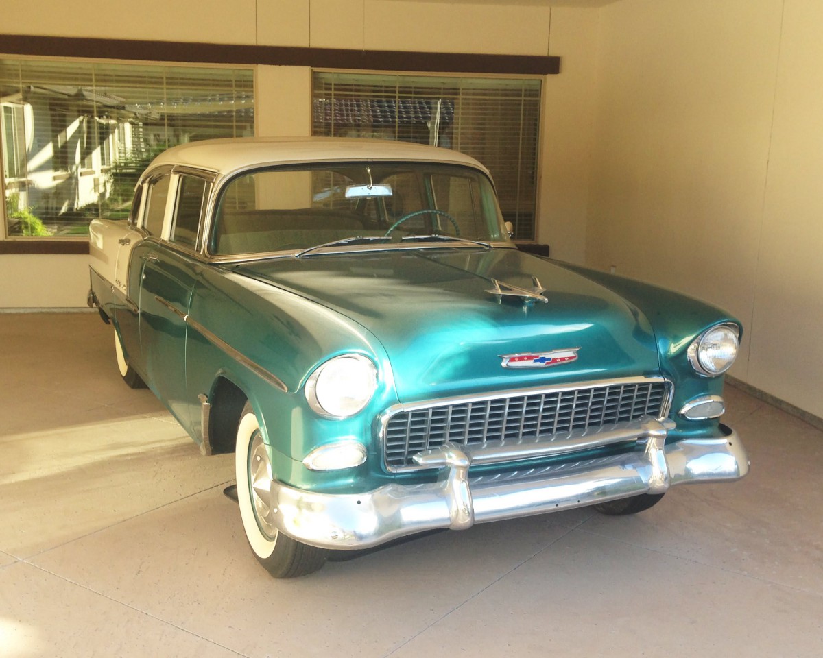 A classic 1950s teal Chevrolet parked in a garage.