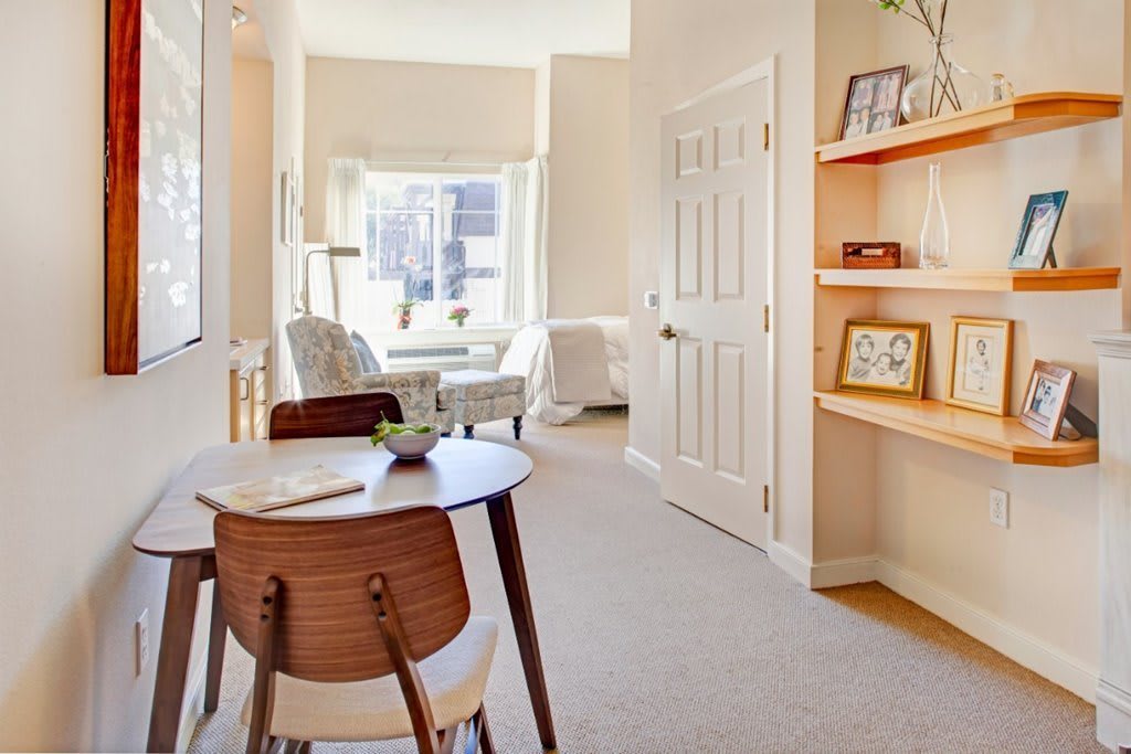 A bright and modern living space with a dining area, featuring natural light and stylish furniture.