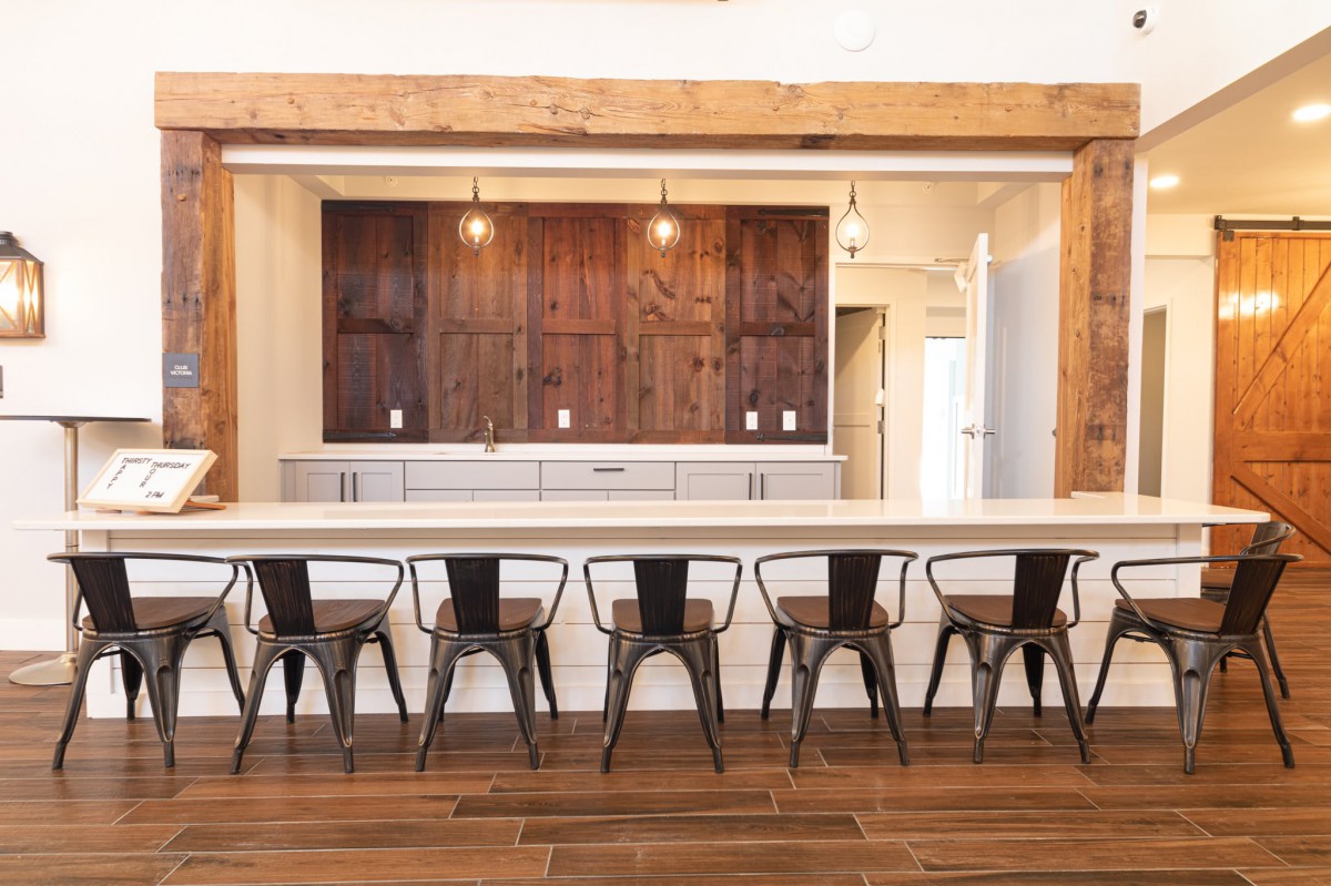 A modern kitchen with a spacious wooden countertop and elegant bar stools.