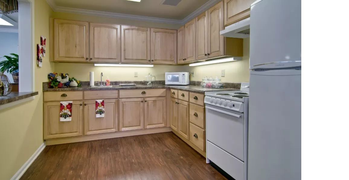 A modern kitchen with wooden cabinets and appliances.