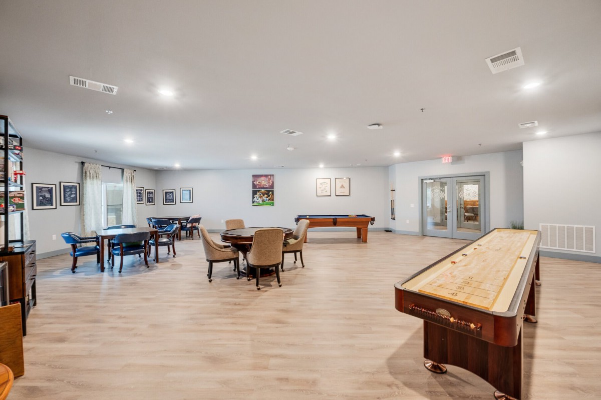 A spacious game room with various tables and recreational activities.