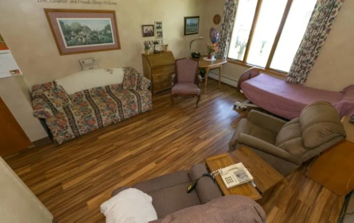 A cozy living room with wooden floors and a variety of furniture including sofas and chairs.