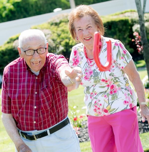 A joyful elderly couple enjoying a sunny day in the garden.