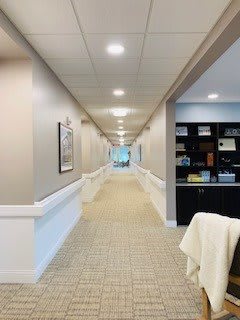 A long office hallway with light fixtures and carpet.