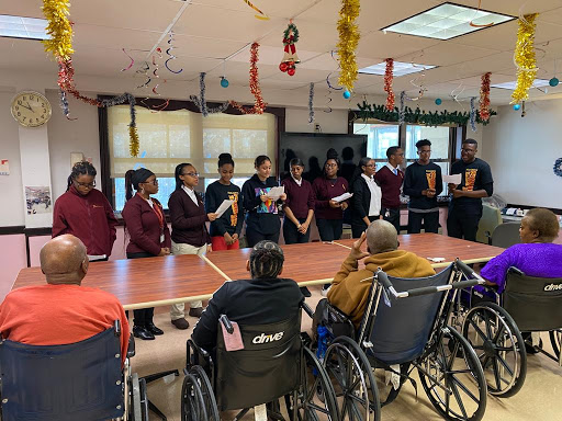 A community event at a care home, where volunteers engage with elderly residents through activities and performances.