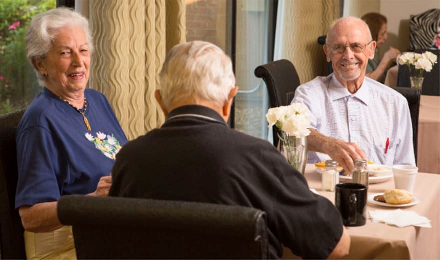 A group of seniors enjoying a meal together at a dining table.