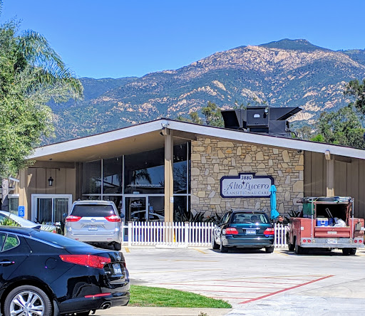 A modern commercial building set against a scenic mountain backdrop.