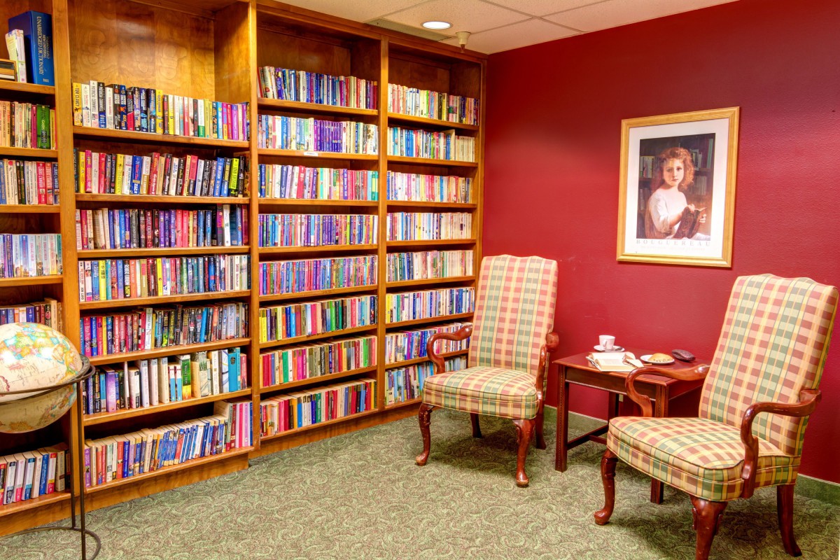 A cozy reading nook with shelves full of books and comfortable chairs.