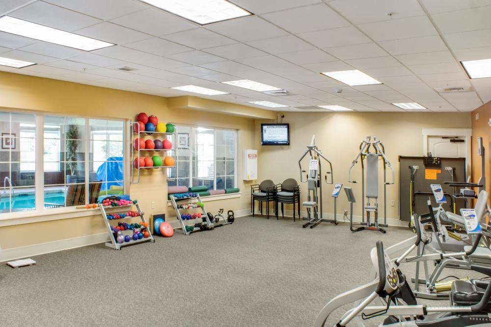 A well-equipped gym with various exercise machines and weights.