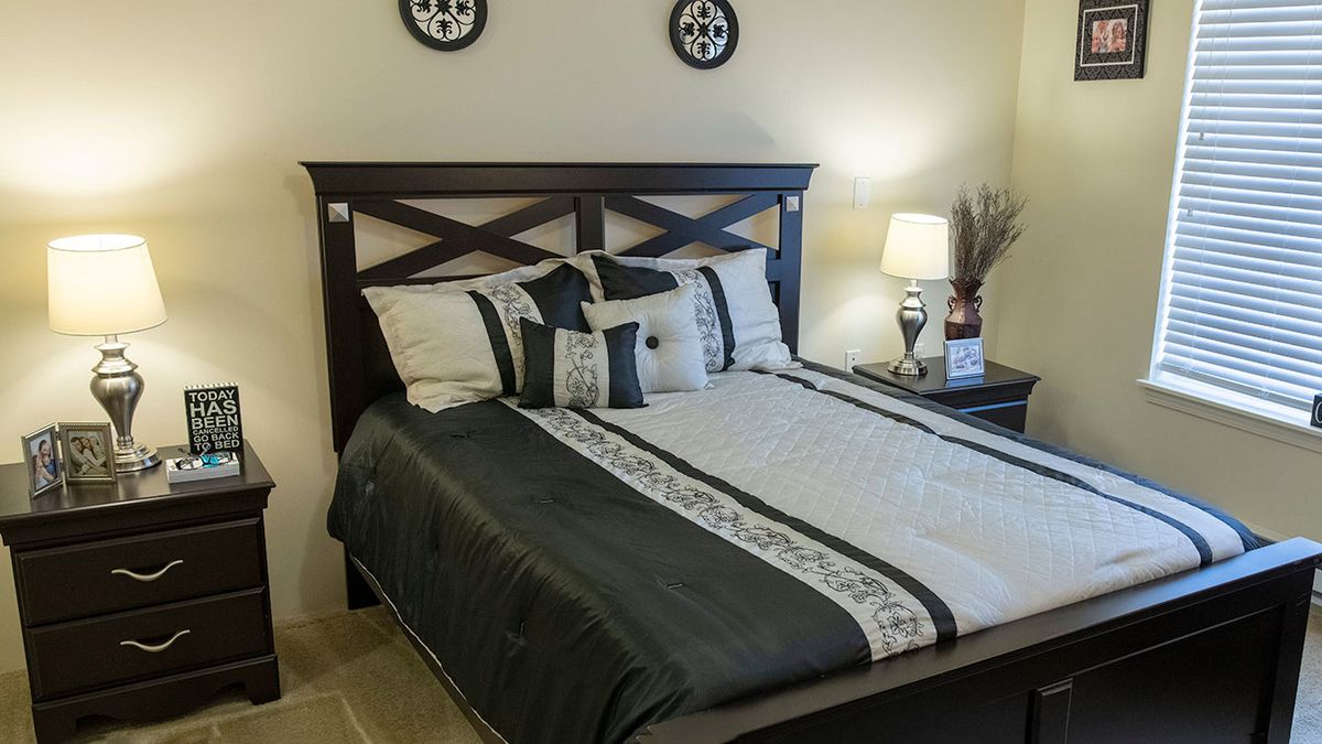 A neatly arranged bedroom with a stylish bed and matching decor.