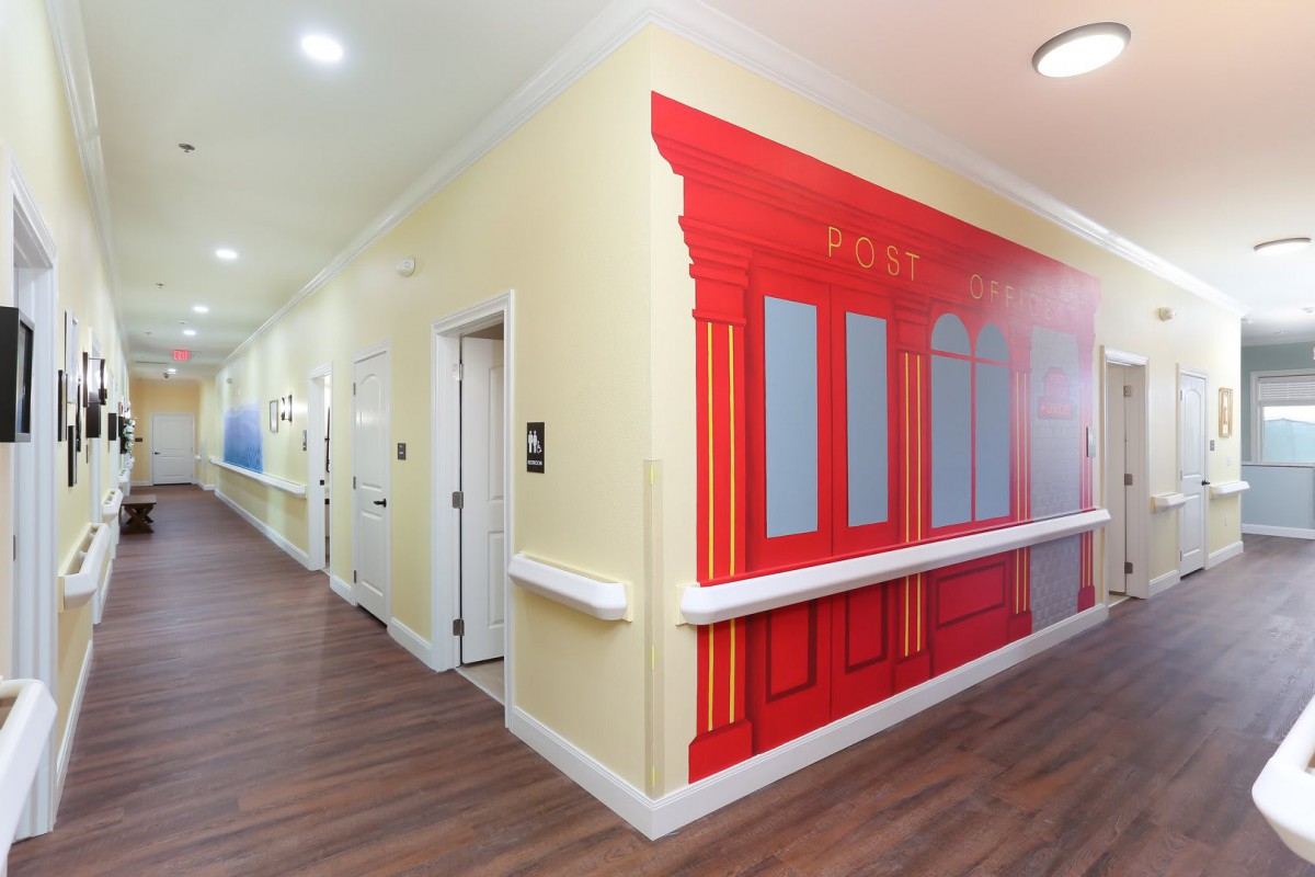 A brightly painted hallway with a mural depicting a storefront faade in a residential setting.