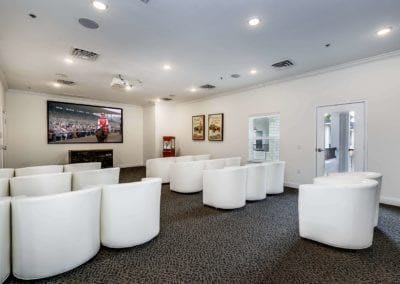 A modern conference room with white seating arranged in rows.