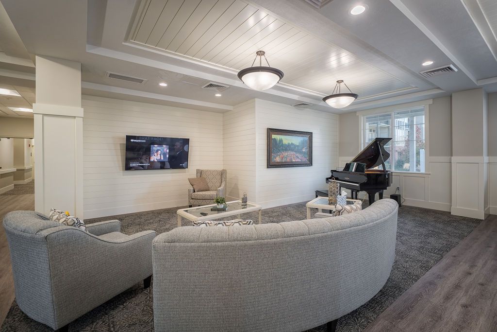 A modern living room featuring elegant decor, a grand piano, and contemporary lighting.