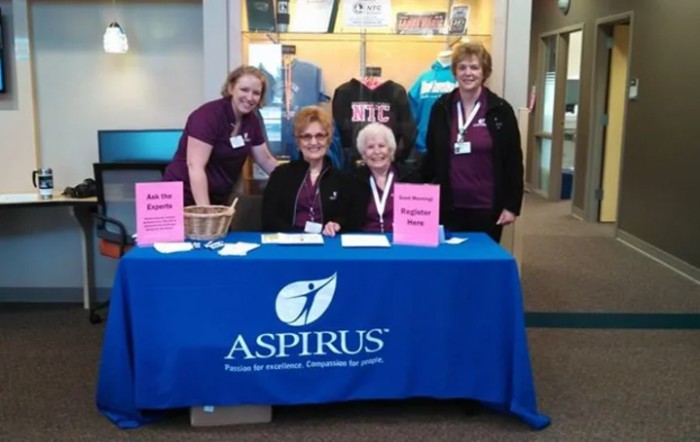 Volunteers at a registration table for an event, featuring Aspirus branding.