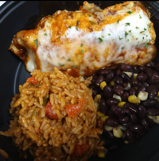 A delicious serving of a burrito accompanied by seasoned rice and black beans.