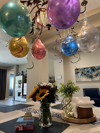 A festive setup with colorful balloons and fresh flowers, perfect for a celebration.