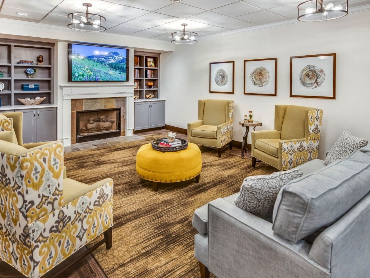 A cozy living room with modern decor, featuring a fireplace, television, and comfortable seating.