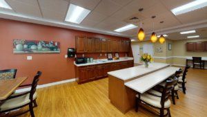 A modern kitchen with wooden cabinets, a large counter, and warm lighting.
