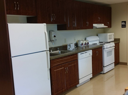 A modern kitchen equipped with essential appliances and wooden cabinets.