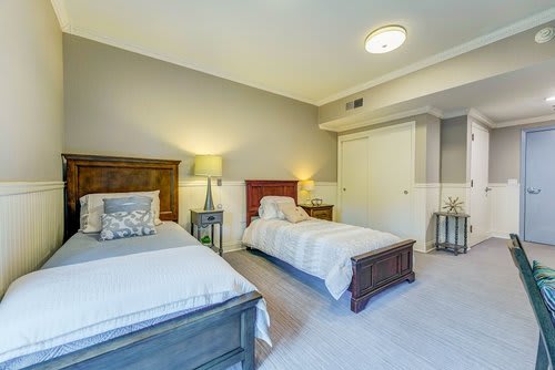 A modern bedroom with two twin beds and soft lighting.