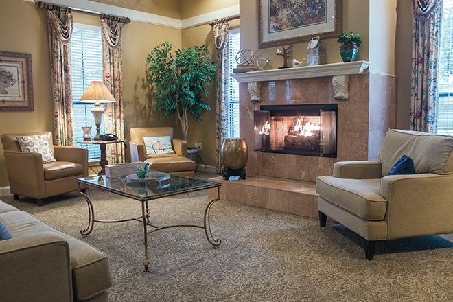 A cozy living room with warm lighting, featuring a fireplace and comfortable seating.