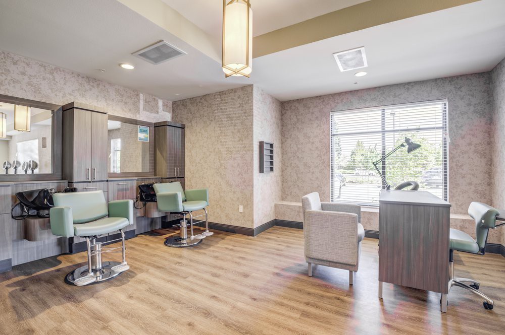 A modern salon interior featuring stylish chairs and wood flooring.