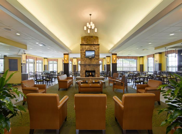 A spacious hotel lobby with comfortable seating and a central fireplace.