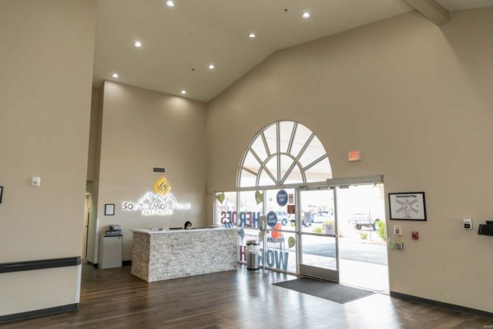 A bright and modern lobby with a reception desk and large glass doors.