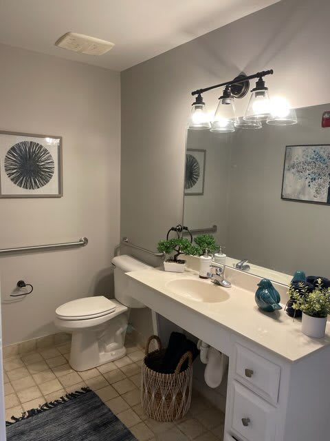 A modern bathroom with a large mirror, white countertop, and decorative accents.