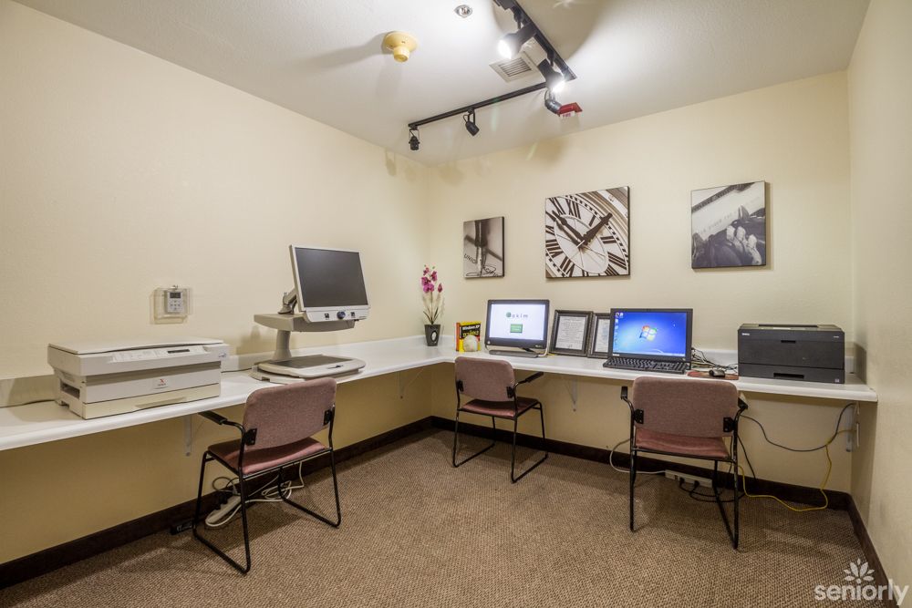 A room with multiple workstations equipped with computers and office equipment.