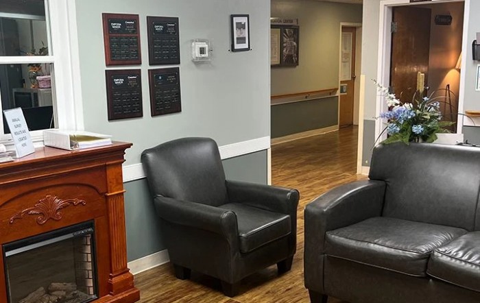 A cozy waiting room with leather chairs and a wooden floor.