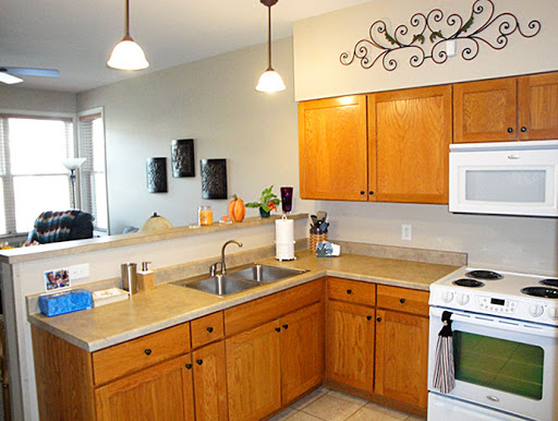 A bright and modern kitchen featuring wooden cabinets, a clean countertop, and ample lighting.