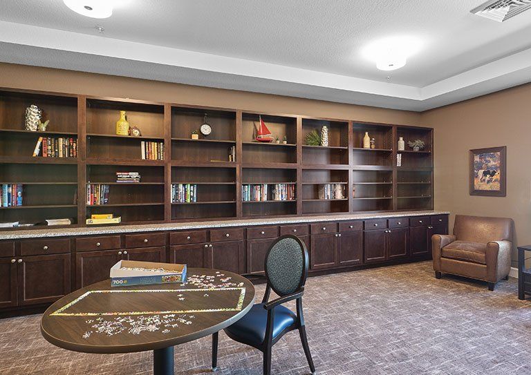 A cozy library reading area with wooden bookshelves and comfortable seating.