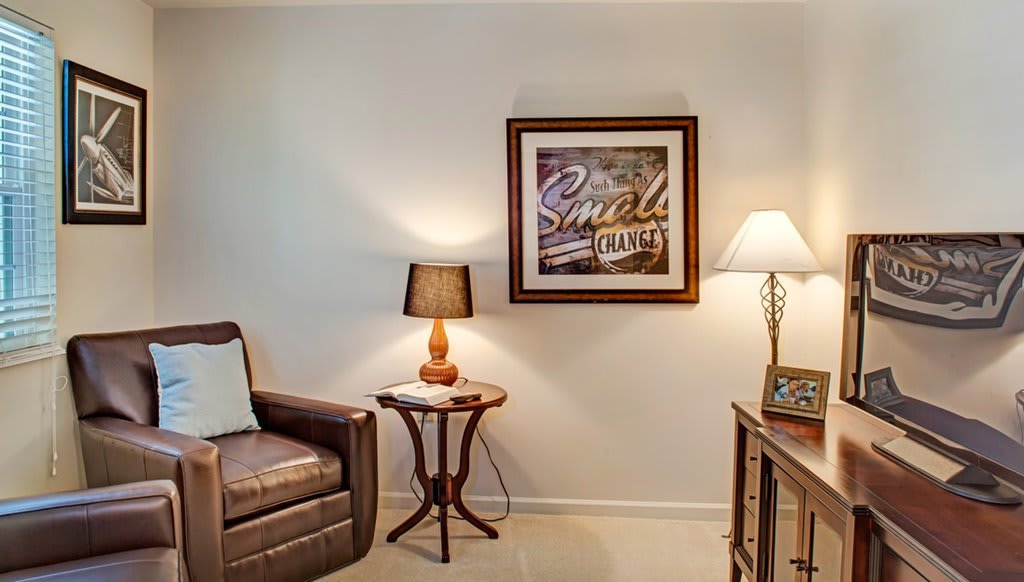A cozy living room corner with an armchair, side table, and decorative lighting.