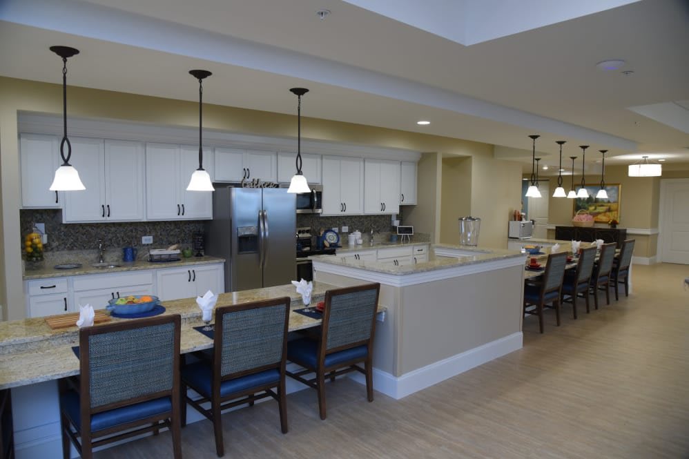 A modern kitchen with a dining area featuring counter seating and elegant lighting.