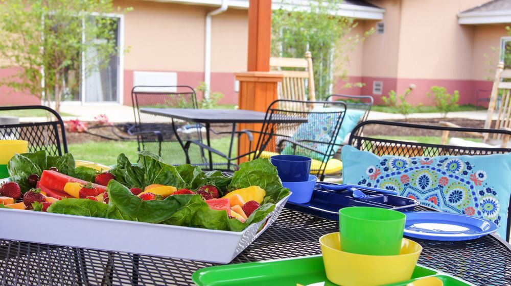 A vibrant outdoor patio setup with a fresh salad and colorful dishes.