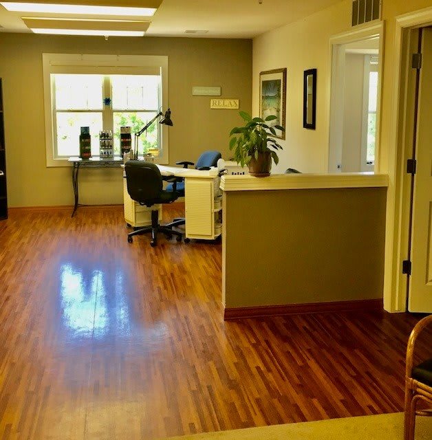 A bright and modern office interior with wooden floors, desks, and chairs.