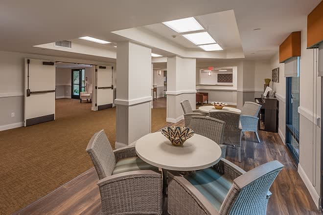 A cozy lounge area with tables and chairs under soft lighting.