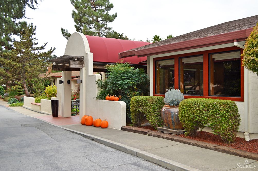 Entrance to a restaurant adorned with seasonal pumpkins and lush greenery.