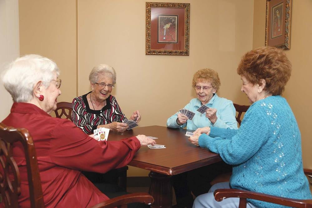 A group of seniors enjoying a game of cards together indoors.