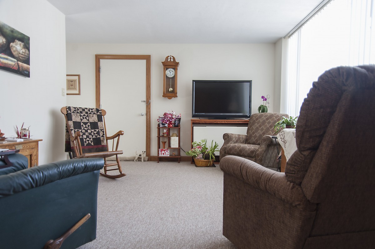 A cozy living room with a television, rocking chair, and comfortable seating.