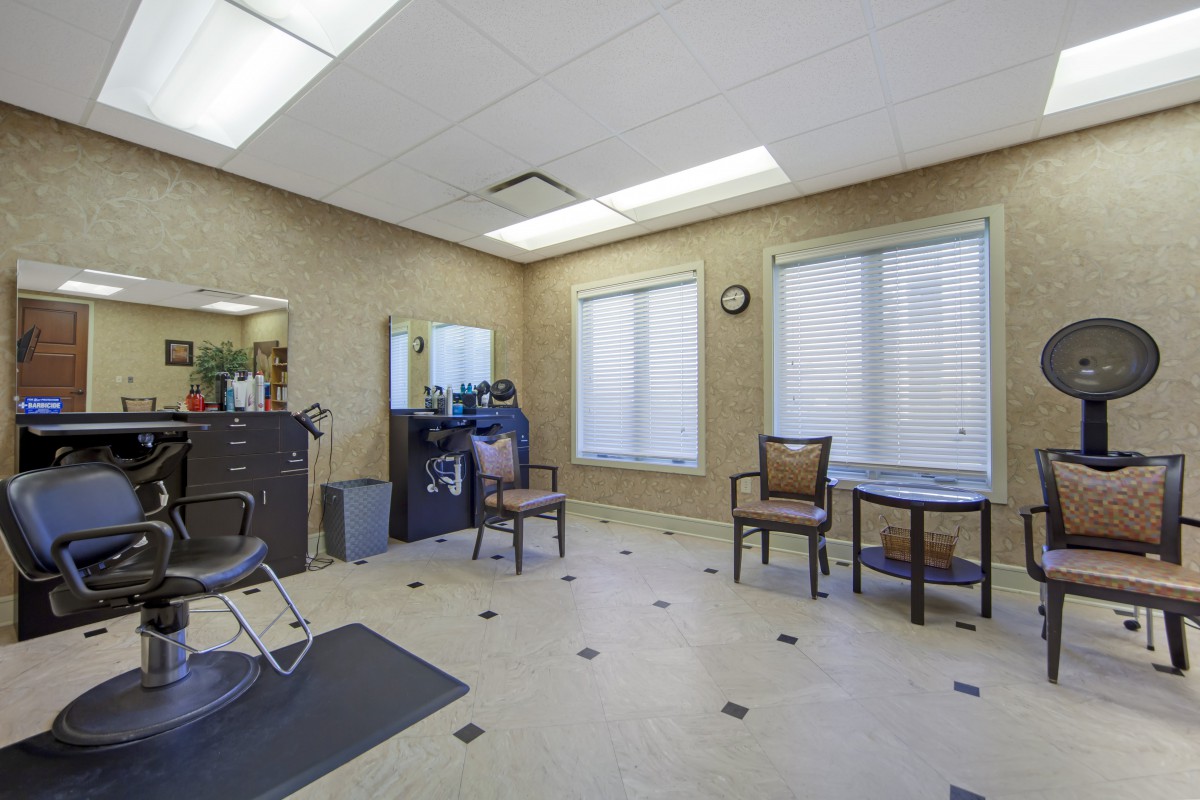 A clean and organized salon waiting area with chairs and mirrors.