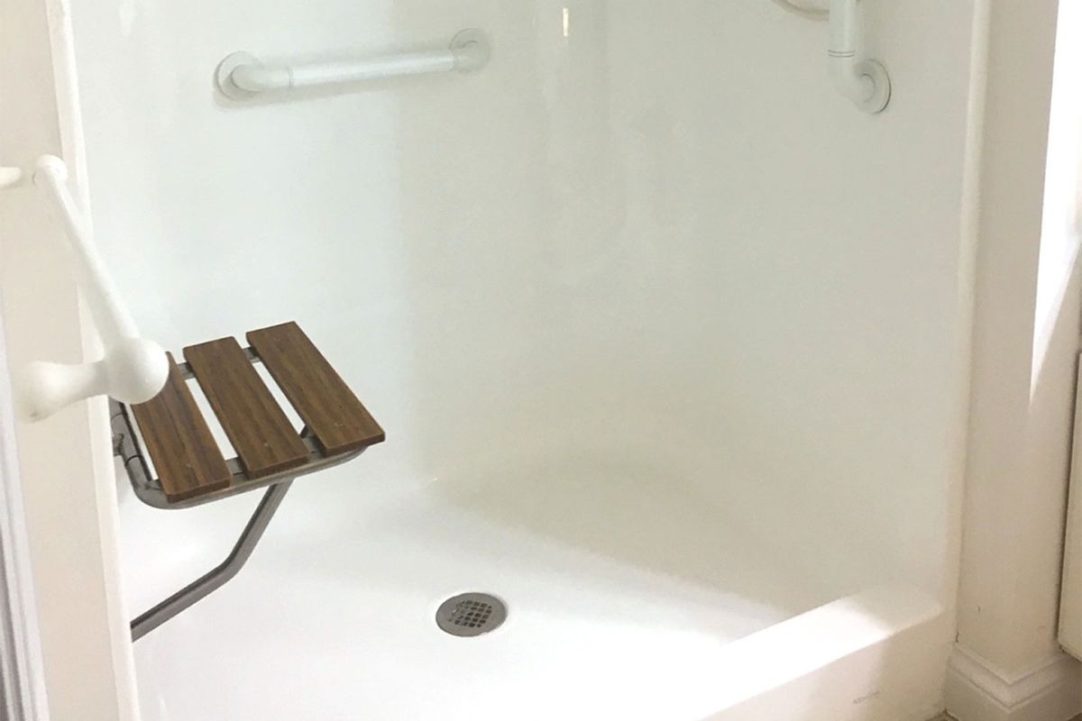 Accessible shower with seating and grab bars.