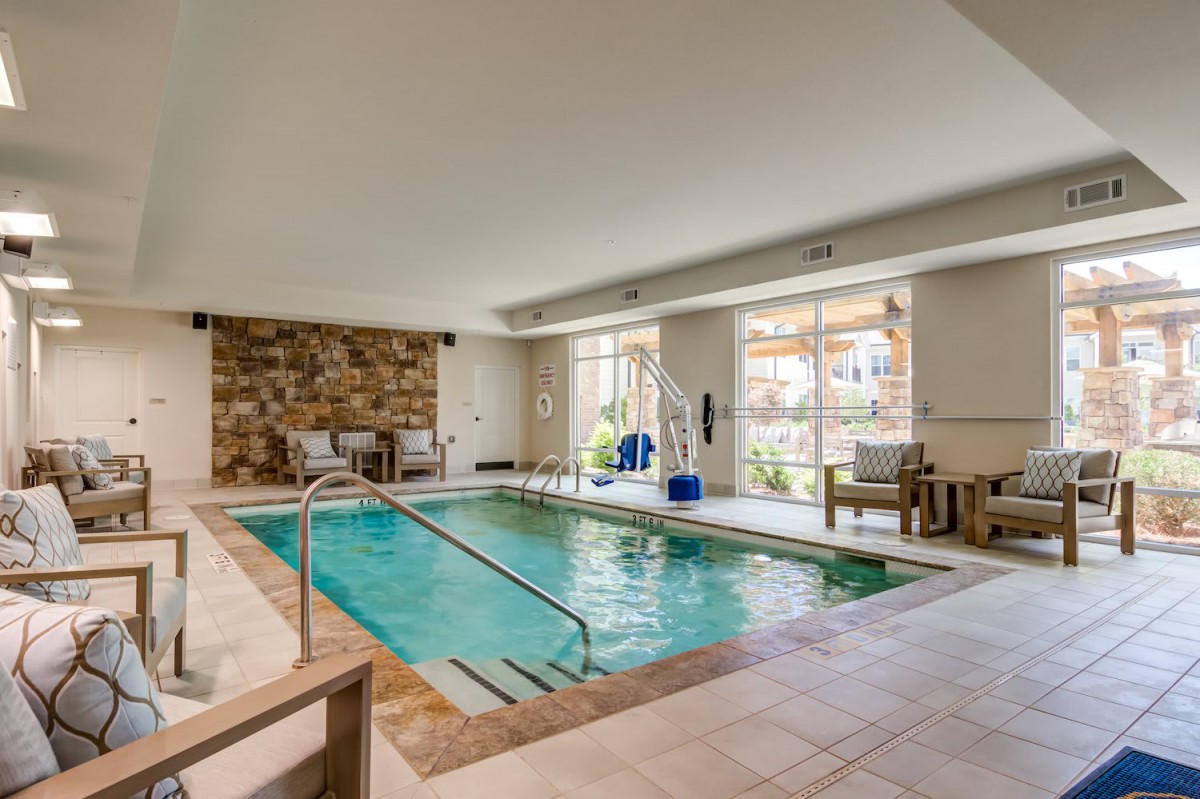 A luxurious indoor pool area with natural light and modern furnishings.